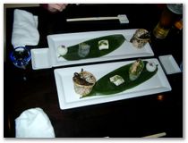 Modernes japanisches Essen, kleine Fischchen, Tomate mit Tofu, Krebsfleisch-Spargel-Wrap und ein Reisbaellchen (v.l.n.r.)